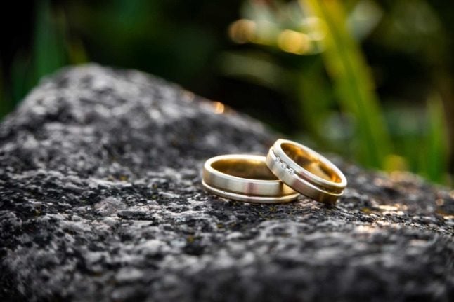 Two golden wedding rings on a rock