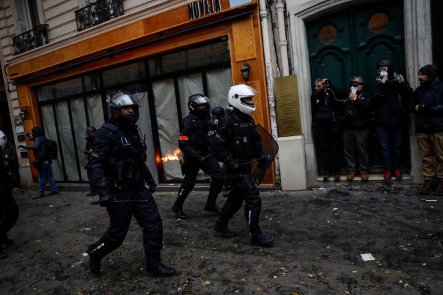 Paris police use tear gas to disperse rioters as tens of thousands protest