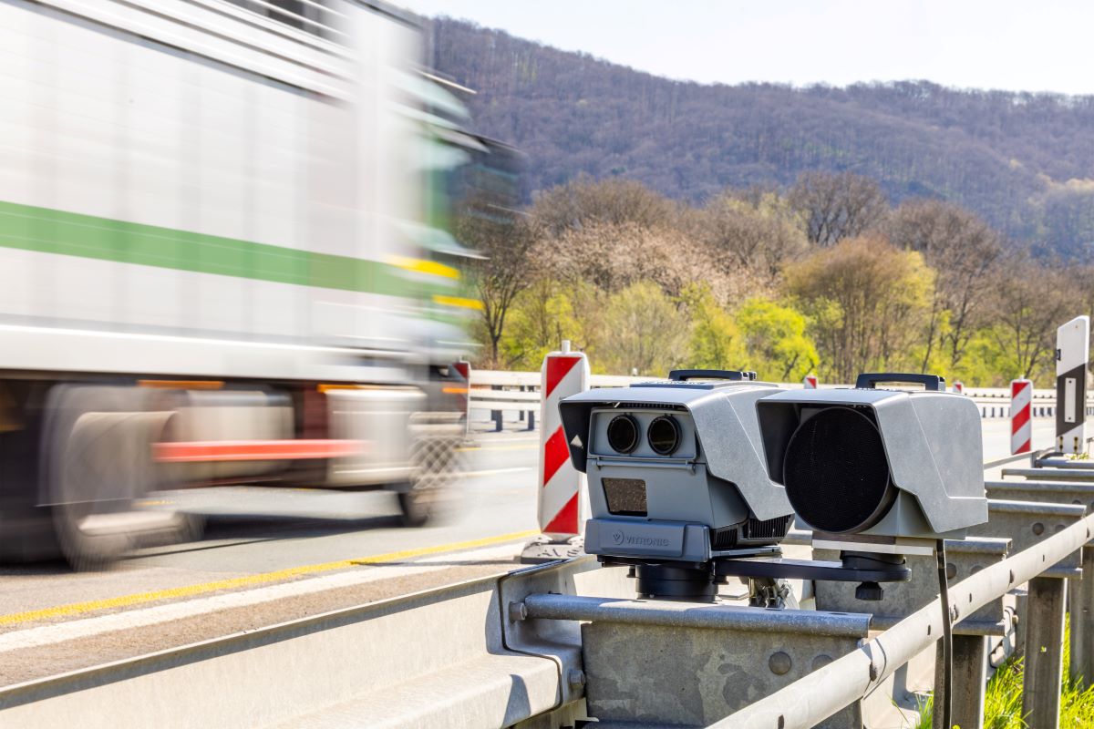 A truck drives past a mobile speed camera on the highway.