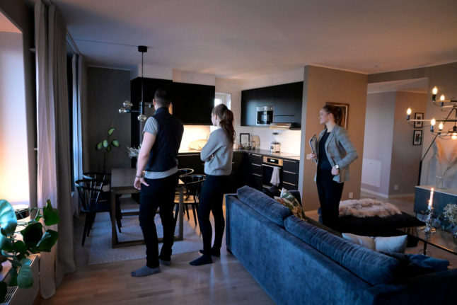 an estate agent showing an open plan kitchen to two people