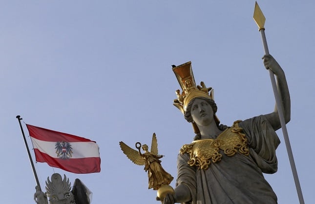 The Austrian flag flies above the parliament building
