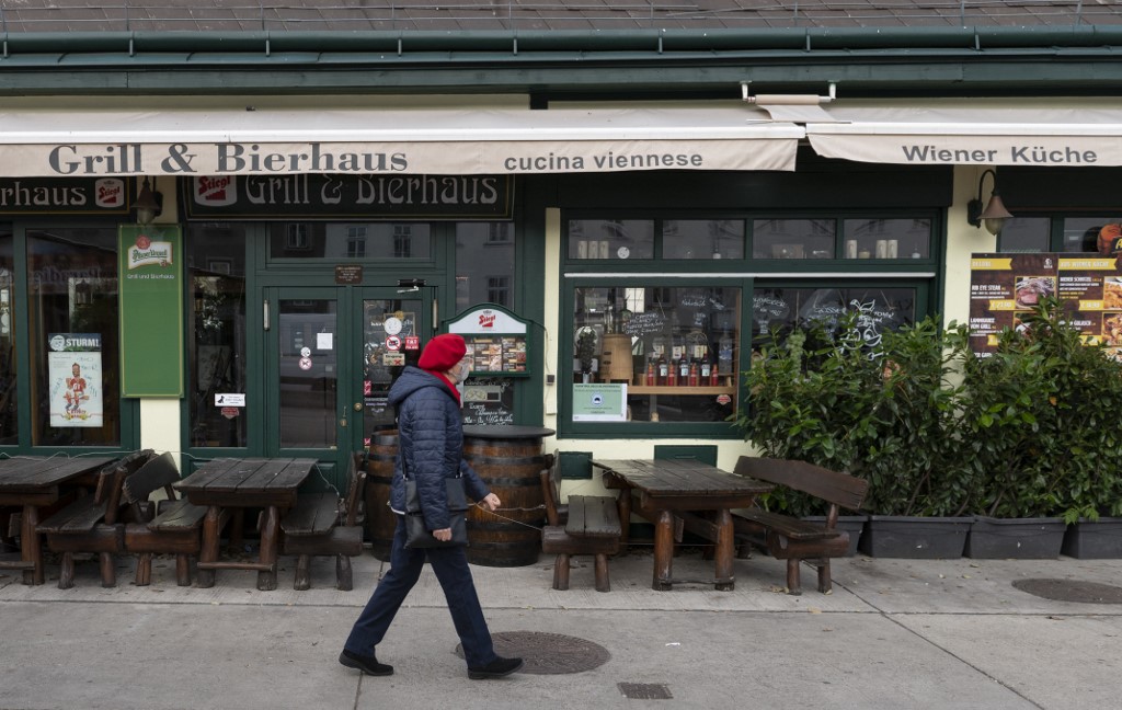 A woman walks past a closed restaurant in the Naschmarkt JOE KLAMAR AFP