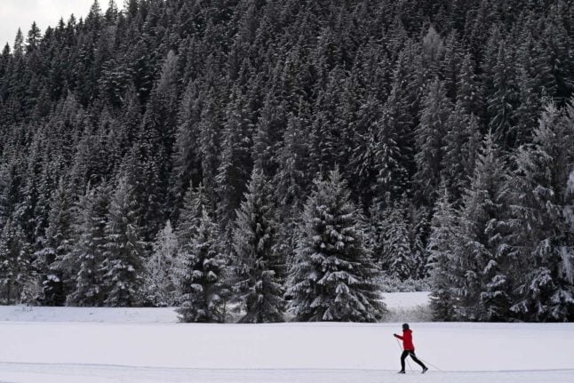A cross country skier walks through the snowy landscape near the village of Ramsau at the Dachstein mountains in Austria.
