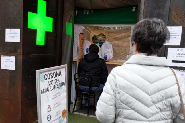 People line up outside a pharmacy offering free coronavirus testing. 