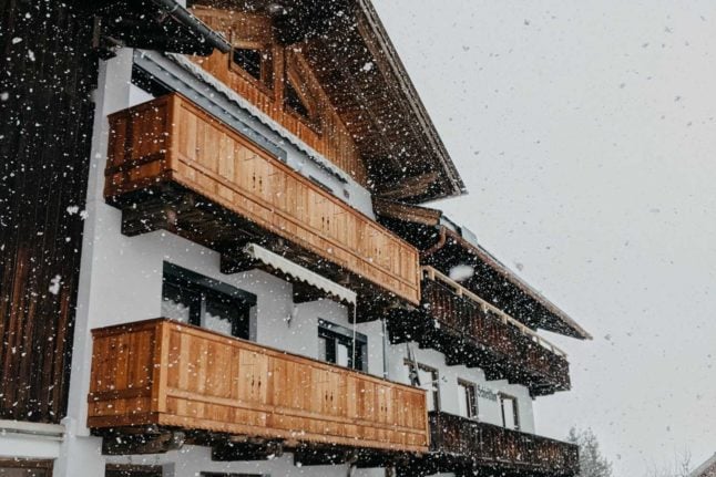 A wooden panelled Austrian home is kissed by petite snowflakes on a cosy day. Photo by Jara from Pexels