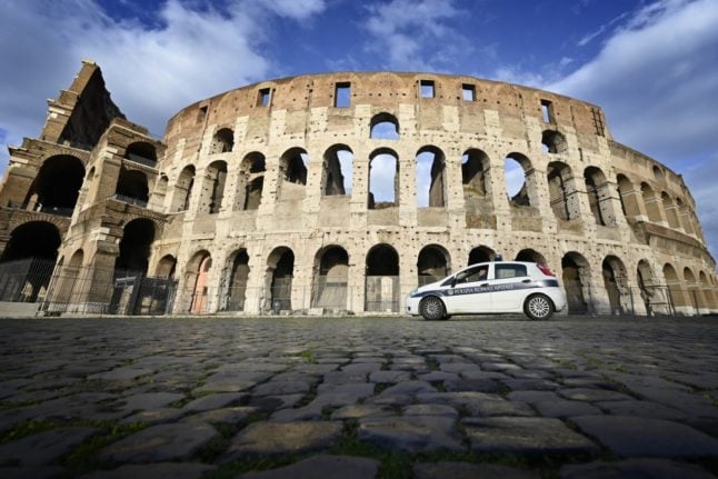 A police car patrols outside the Colosseum in Rome.