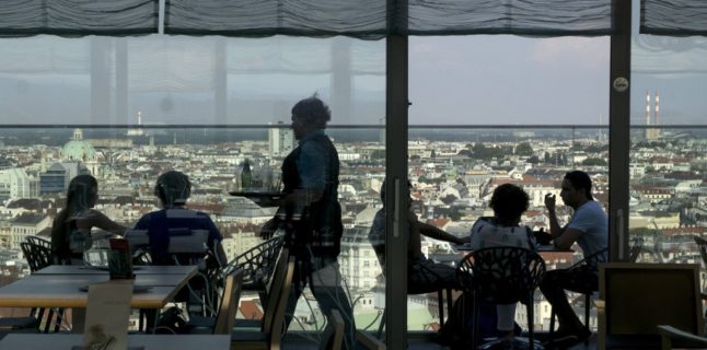 A waitress serves guests at a roof-top cafe in Vienna. (Photo by JOE KLAMAR / AFP)