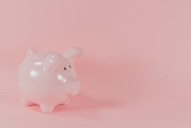 A piggy bank against a pink background