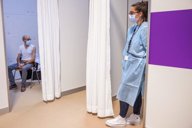 A person waits to get a vaccine in Switzerland for Covid. Photo: Photo by Valentin FLAURAUD / AFP