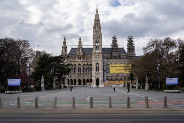Screens projecting hygiene measures to curb the spread of the Covid-19 pandemic can be seen outside the city hall in Vienna (Photo by JOE KLAMAR / AFP)
