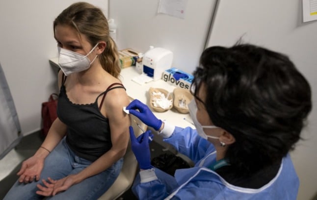 A woman recieves a vaccine. Photo by STEPHANE DE SAKUTIN / AFP)
