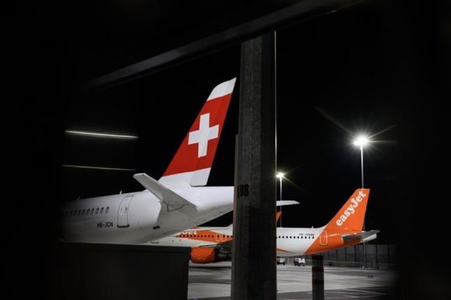 Commercial planes of Swiss airline and low cost airline EasyJet are seen parked due to flight interruption amid the COVID-19 outbreak.. (Photo by Fabrice COFFRINI / AFP)