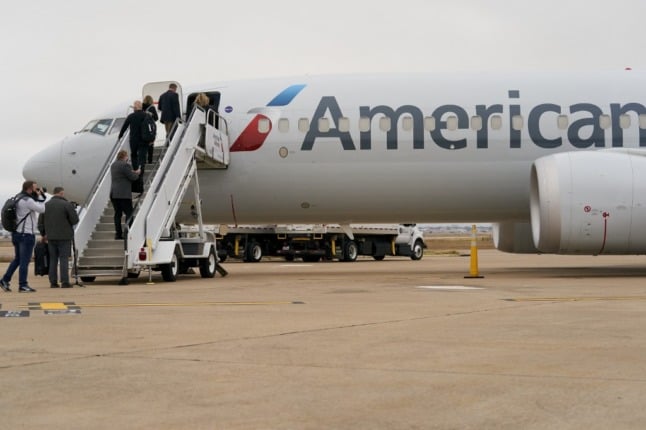 Passengers board an American Airlines plane to Spain