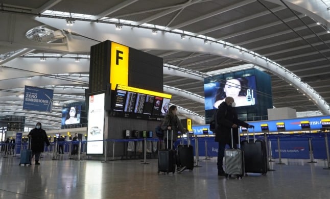 Travellers wearing face masks arrive at London’s Heathrow Airport.