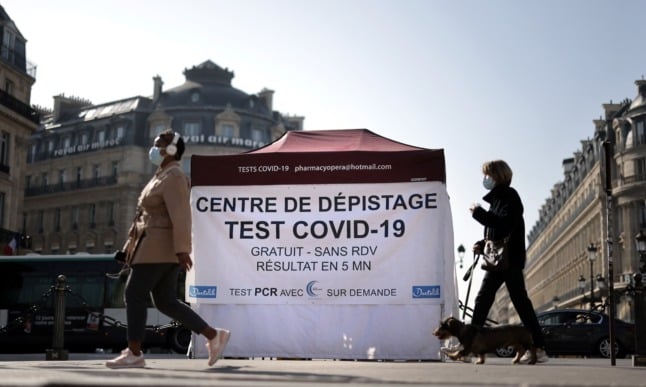 People walking past a pop-up Covid test centre at the Opera square in Paris. Tests were previously free for residents.