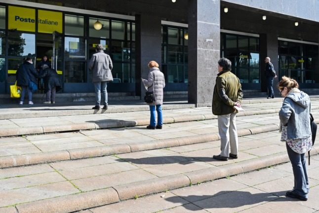 People queue outside a post office in Rome. Alberto PIZZOLI / AFP