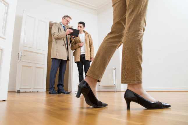 A couple is shown around a flat by an estate agent