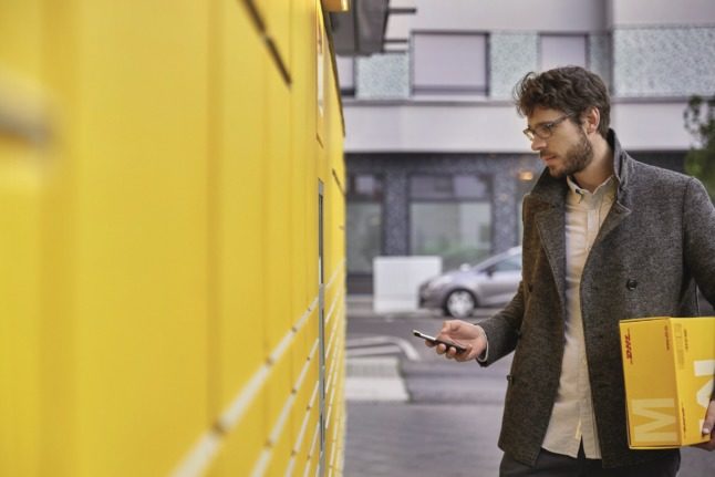 A man collects his post at a Deutsche Post Packstation in Germany.