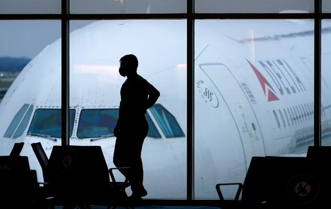 a man in front of a plane at a US airport