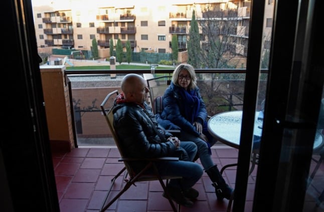 man and woman sit on balcony in flat in Spain