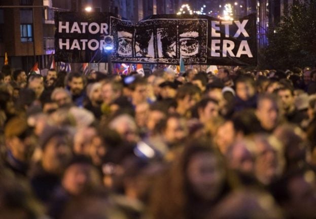 People hold a banner reading in Basque 