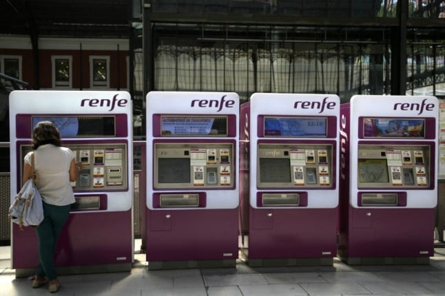 A woman buys train tickets on an automatic ticket machine of the Spanish state-owned rail company Renfe, at the Principe Pio train station in Madrid, on September 5, 2019. (Photo by GABRIEL BOUYS / AFP)