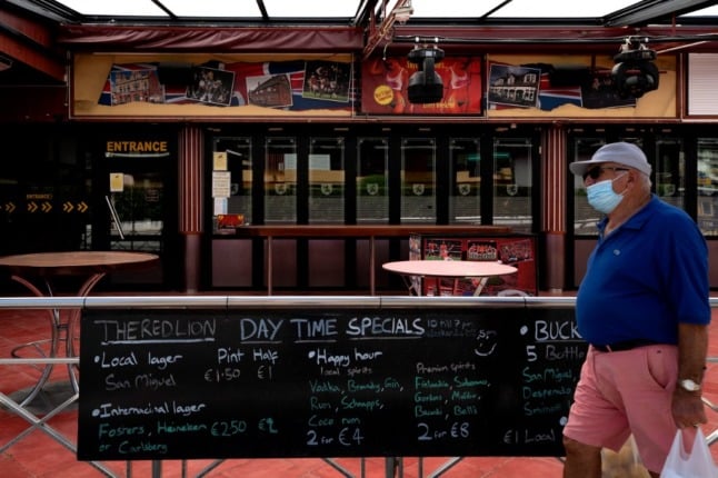 A man walks past a closed British pub in Benidorm on June 1, 2020.