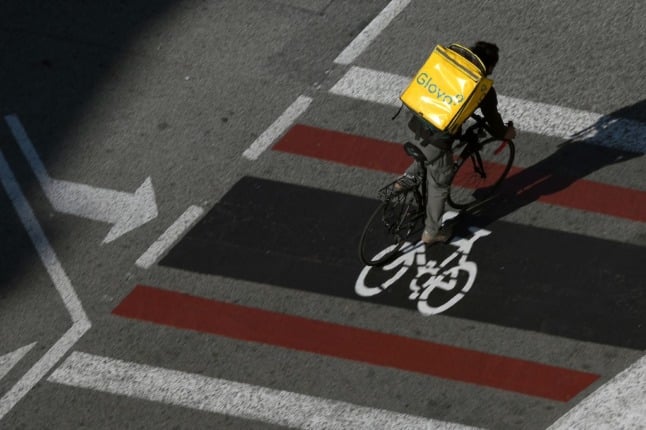 A Glovo delivery worker rides in Barcelona