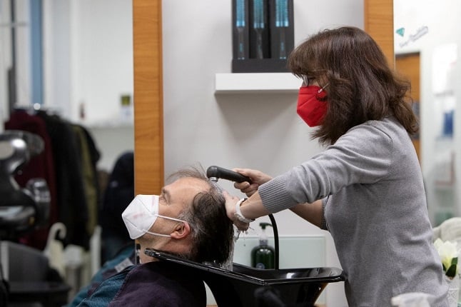 A hairdresser and customer wearing face masks at a hair salon