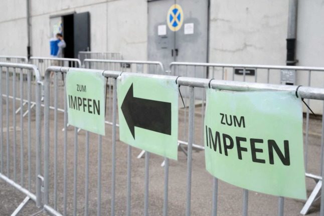 A sign says 'to vaccinations' in German. Photo: THOMAS KIENZLE / AFP