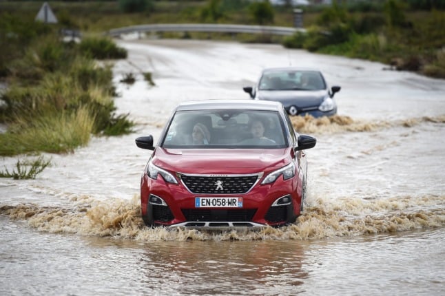 A woman drivers her car in a flooded road in the Gard department on September 14th.