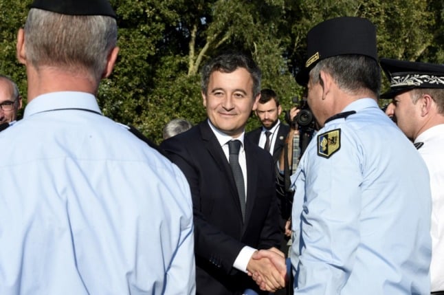 French Interior Minister Gerald Darmanin shakes with law enforcement officers during a visit to northern France.