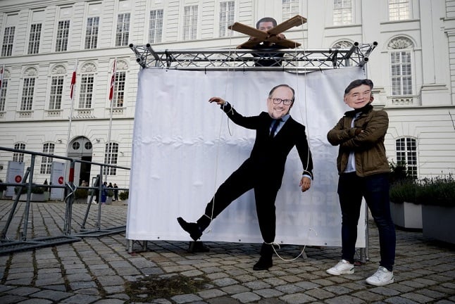 Protestors wear masks showing Sebastian Kurz as a puppeteer, pulling the strings of successor Alexander Schallenberg as Vice Chancellor Wolfgang Kogler looks on. Photo: Joe Klamar/AFP