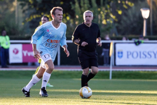 President Macron plays the ball during a football match as part of the celebration of the fiftieth anniversary of the 'Varietes club de France'.