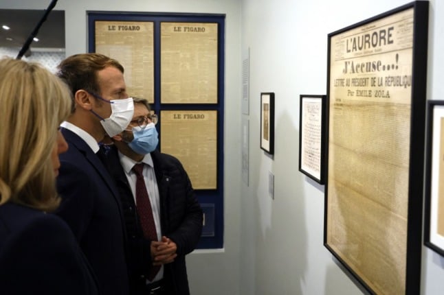 French President Emmanuel Macron, flanked by his wife Brigitte Macron and Grand Rabbi of France Haim Korsia look at author Emile Zola's J'Accuse! open letter published on the front page of L'Aurore newspaper in 1898.