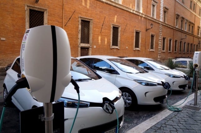 Three white Renault Zoe electric cars connected to streetside charging points
