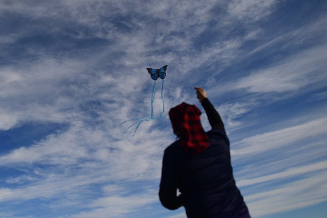 A man flies a butterfly-shaped kite. A kite in French is a 'cerf volant' - flying deer.