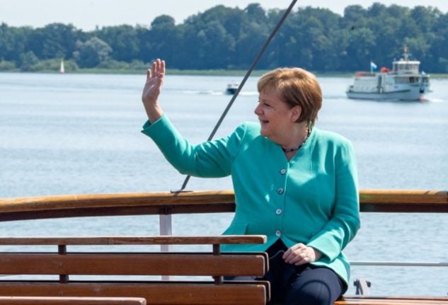 Chancellor Angela Merkel waves from a boat on the Chiemsee during a trip to visit Bavarian premier Markus Söder in July 2020. 