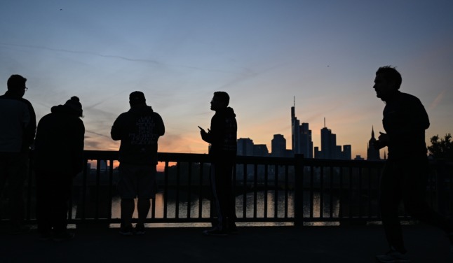 Passers-by watch the sunset in Frankfurt on October 11th. 