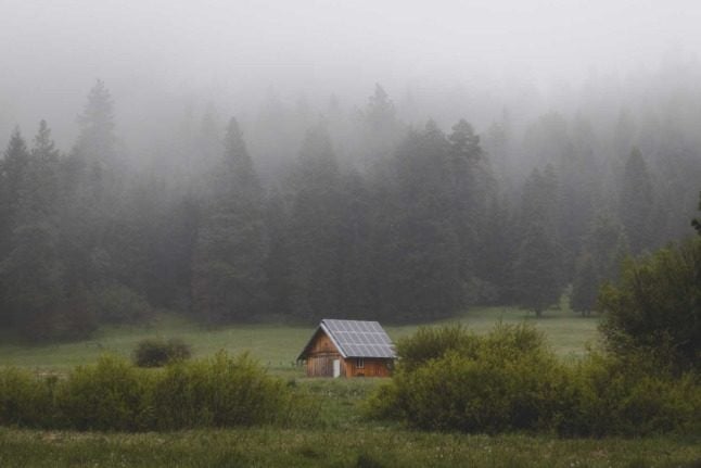 A cottage in the middle of a field with solar panels on the roof. How do you convert to solar in Austria? Photo by Alex Bierwagen on Unsplash
