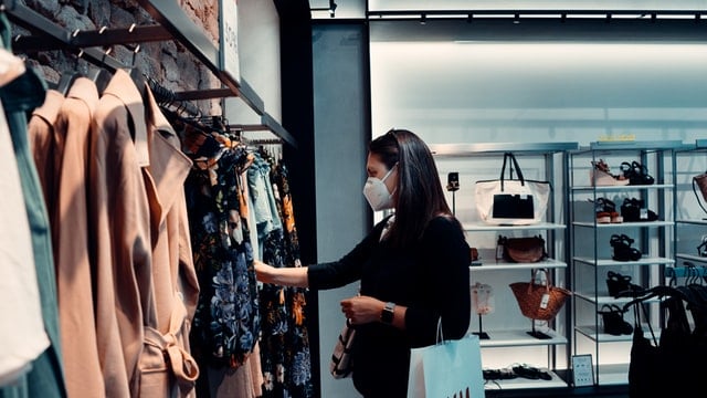 Woman wears FFP2 face mask in clothes shop