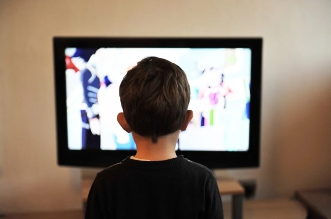 child watches tv ads promoting sweets