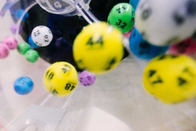 Colourful lottery balls fall out of a bucket. There are several vaccination lotteries on offer in Austria. Photo by dylan nolte on Unsplash
