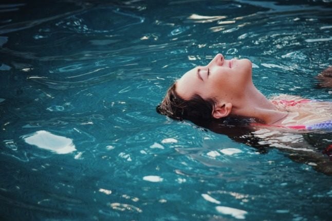A woman swims in a spa pool.