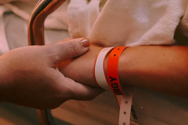 People holding hands in a hospital bed