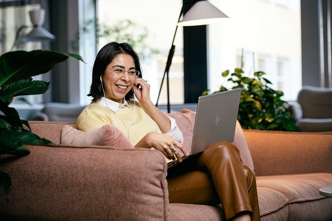 Woman working on laptop from sofa