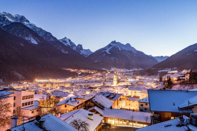 The beautiful Tirolean countryside, with the lights of a village shining bright. Photo by Matthias Betz on Unsplash