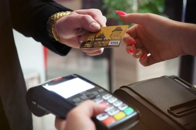 A person pays with a card. Card payments are still relatively uncommon in Switzerland