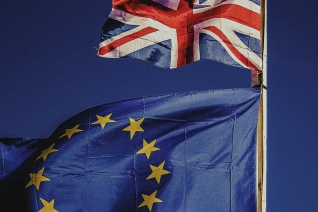 The Union Jack and the European Union flag fly next to each other. Photo by Rocco Dipoppa on Unsplash