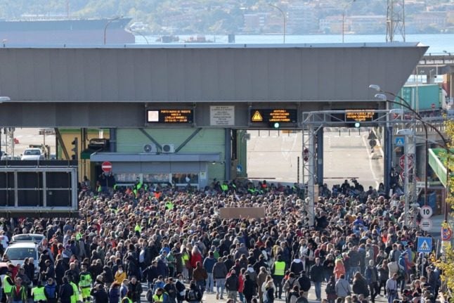 Dockers and port workers gather at the Port of Trieste’s Gate 4 on October 15, 2021 to protest new coronavirus restrictions for workers